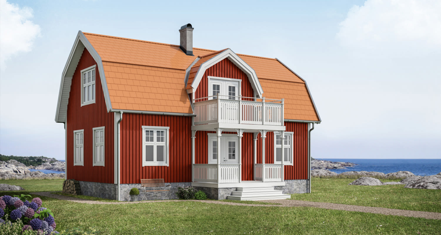 Punainen puutalo valkoisilla listoituksilla ja oranssikatolla merenrannalla.