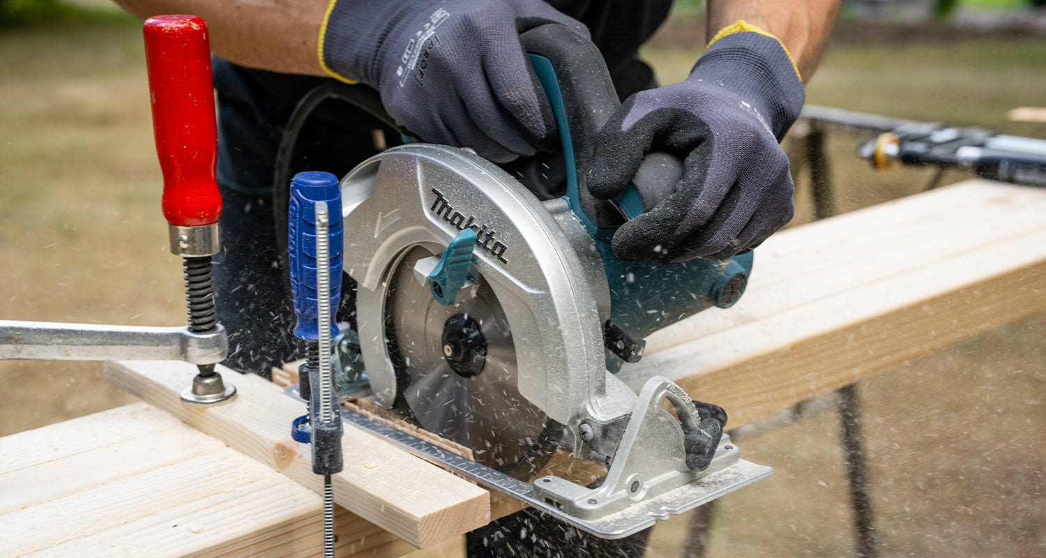 Modernin pergolan rakentaminen. Kuvassa tolppien sahaus.