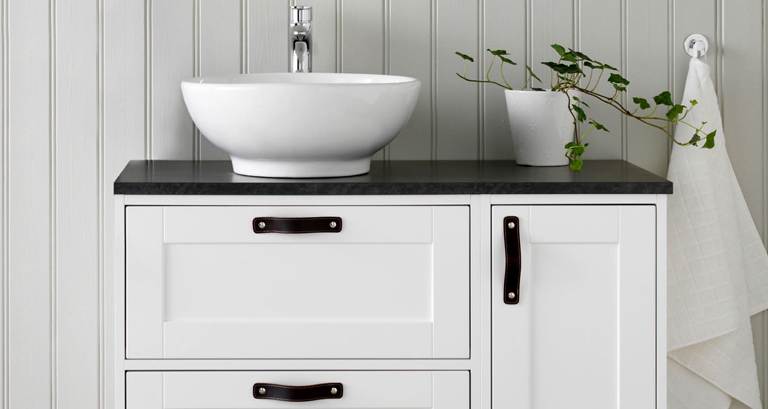 Mustat nahkavetimet romanttisen allaskaapin alaosassa.