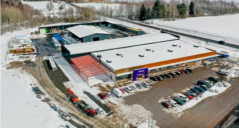 Lentokuva lumisesta Rauta-rakennuksesta, valkoinen katto, punainen teräsrunko ja pysäköityjä autoja