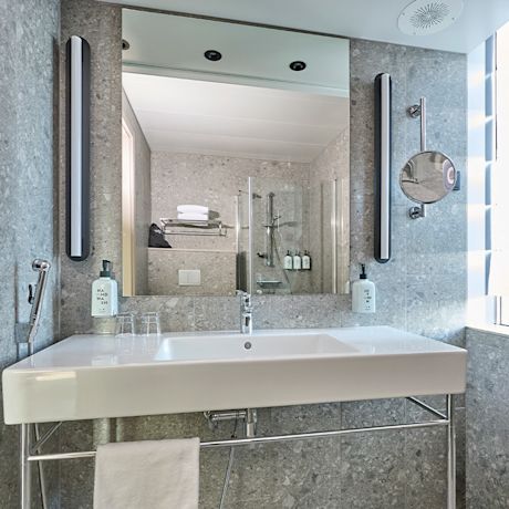 Kylpyhuoneessa Marazzin Ceppo Di Gre -sarjan kivikuvioisia laattoja harmaan sävyssä.