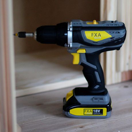 Harmaa-keltainen FXA 18V akkuporakone puuhyllyn sisällä