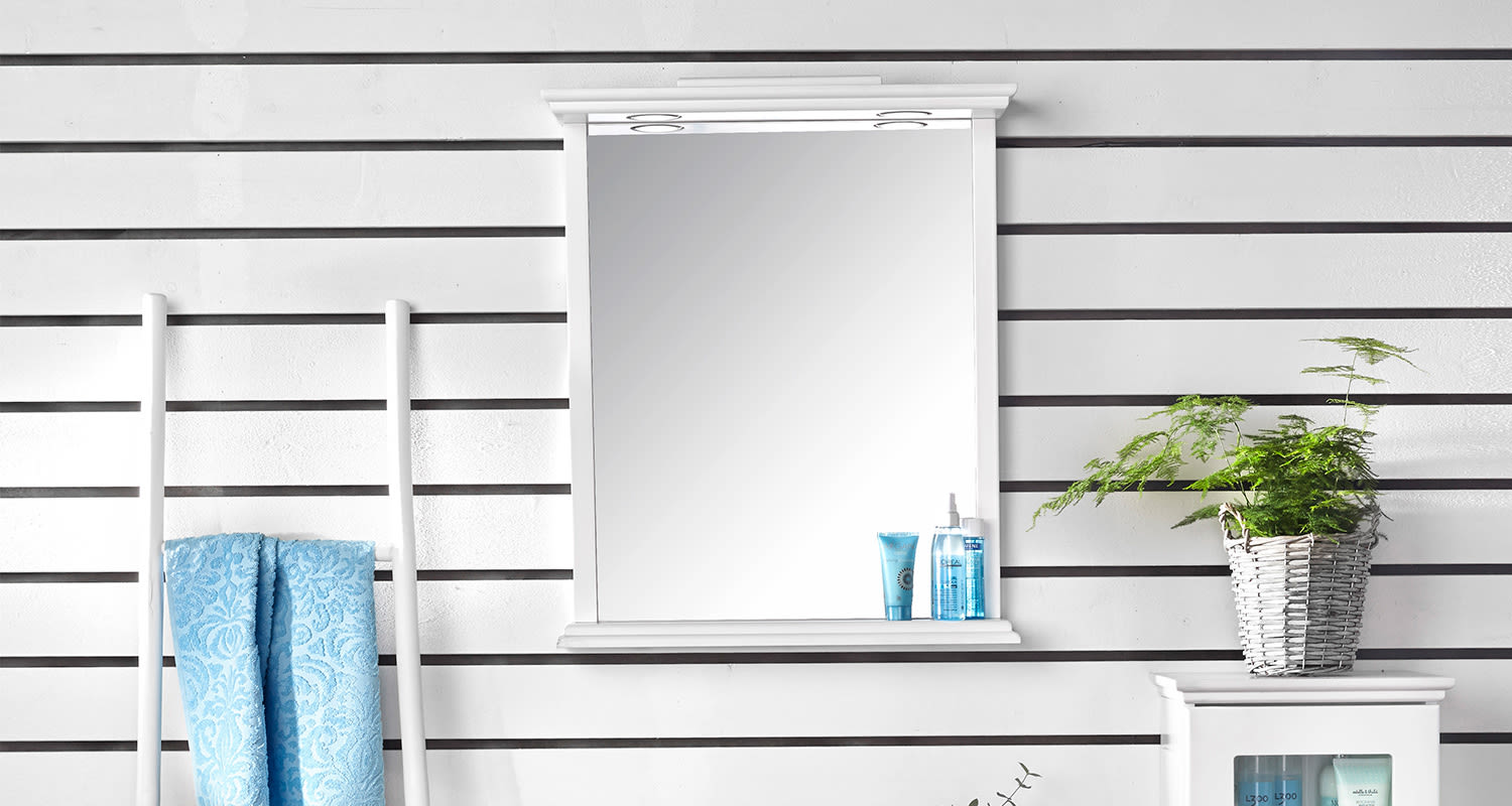 Valkoinen kylpyhuoneen seinä, peili, siniset pyyhkeet, sinisiä purkkeja ja viherkasvi