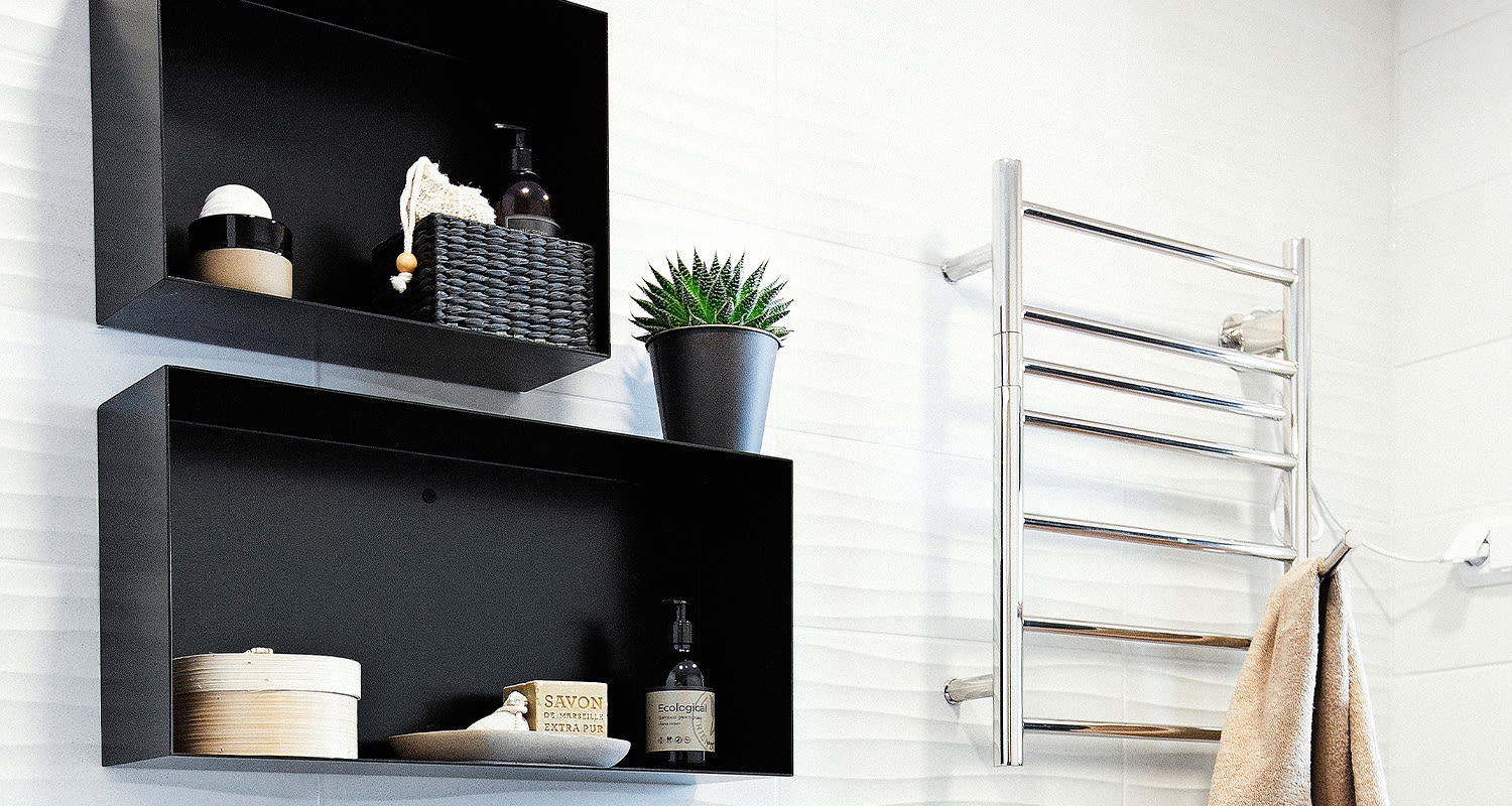 Kodinhoitohuone, jossa kaksi mustaa hyllyä sekä kuivausteline.