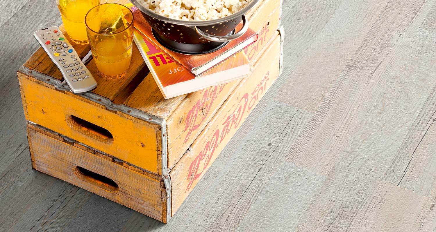 Keltaiset puulaatikot, metallisiivilä popcorneineen, kirja, 2 oranssia lasia ja kaukosäädin