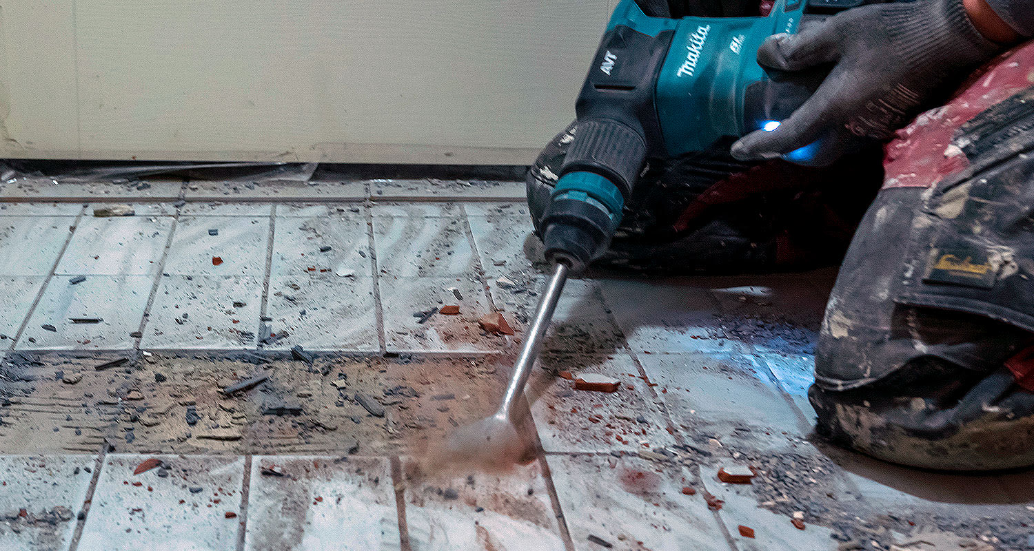 Makitan piikkauskone DHK180Z kylpyhuoneen lattialaattojen piikkauksessa