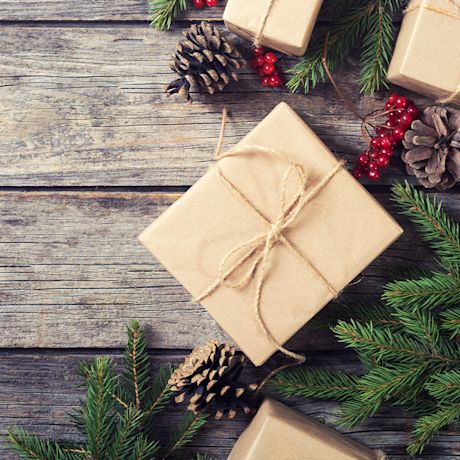 Joululahjaideat: Kuvassa joululahja, käpyjä ja havuja.