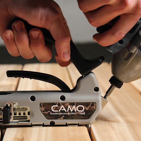 Kädet käyttävät harmaamustaa CAMO Marksman Pro -työkalua puulautojen ruuvikiinnitukseen