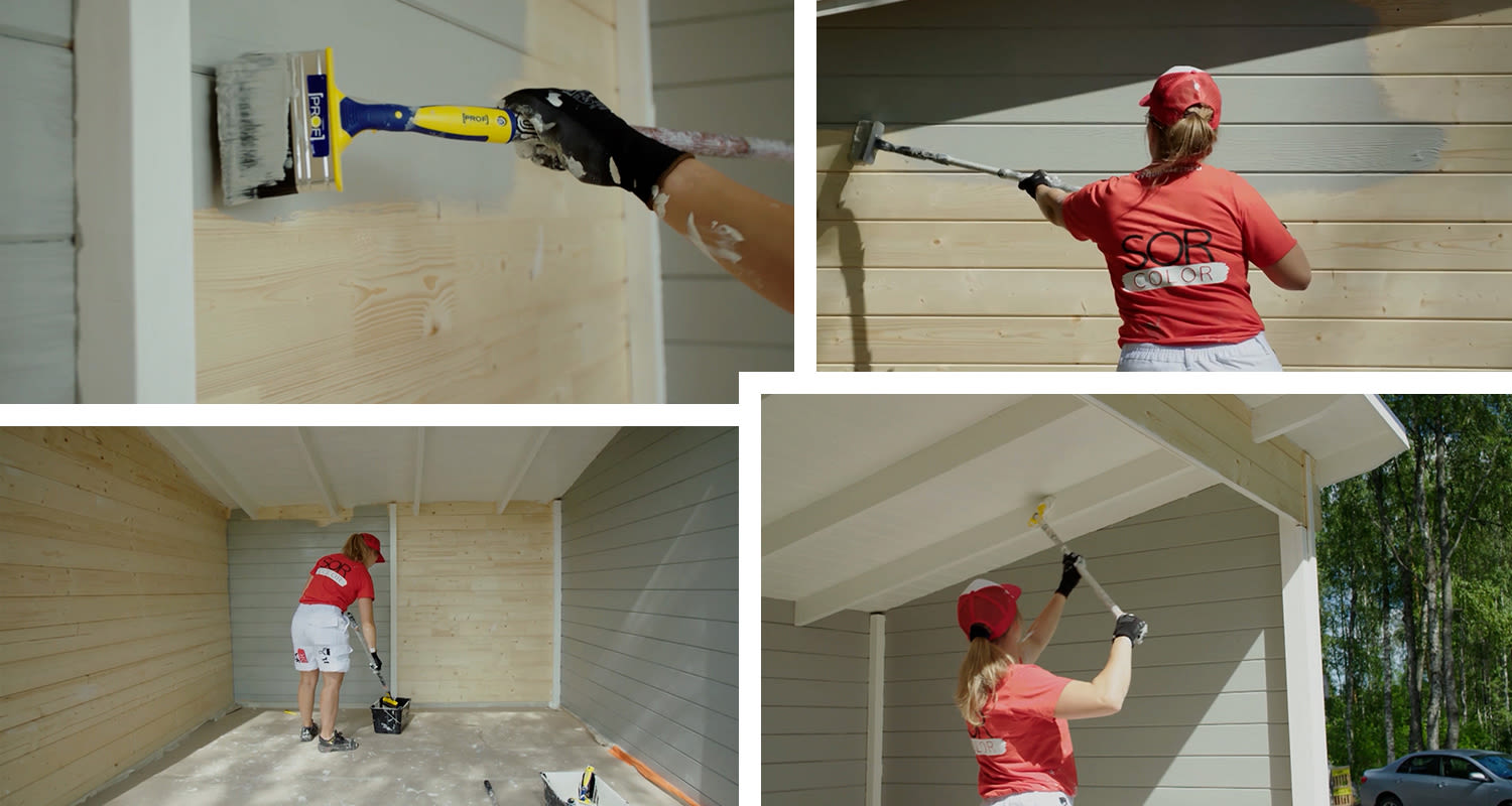 Punapaitainen nainen maalaa vaaleaa puupaneeliseinää harmaaksi pihakatoksessa.