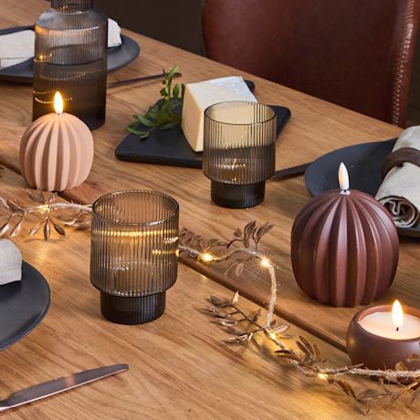 Kuvassa joulun kattaus, jossa mukana kynttilöitä ja valosarjoja.