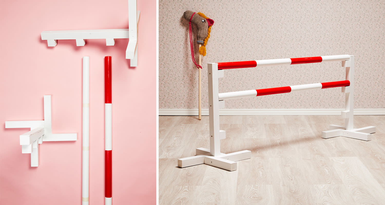 Sisätiloissa valkoiset puutolpat punavalkoraidoilla, keppihevonen kukkakuvioisella taustalla