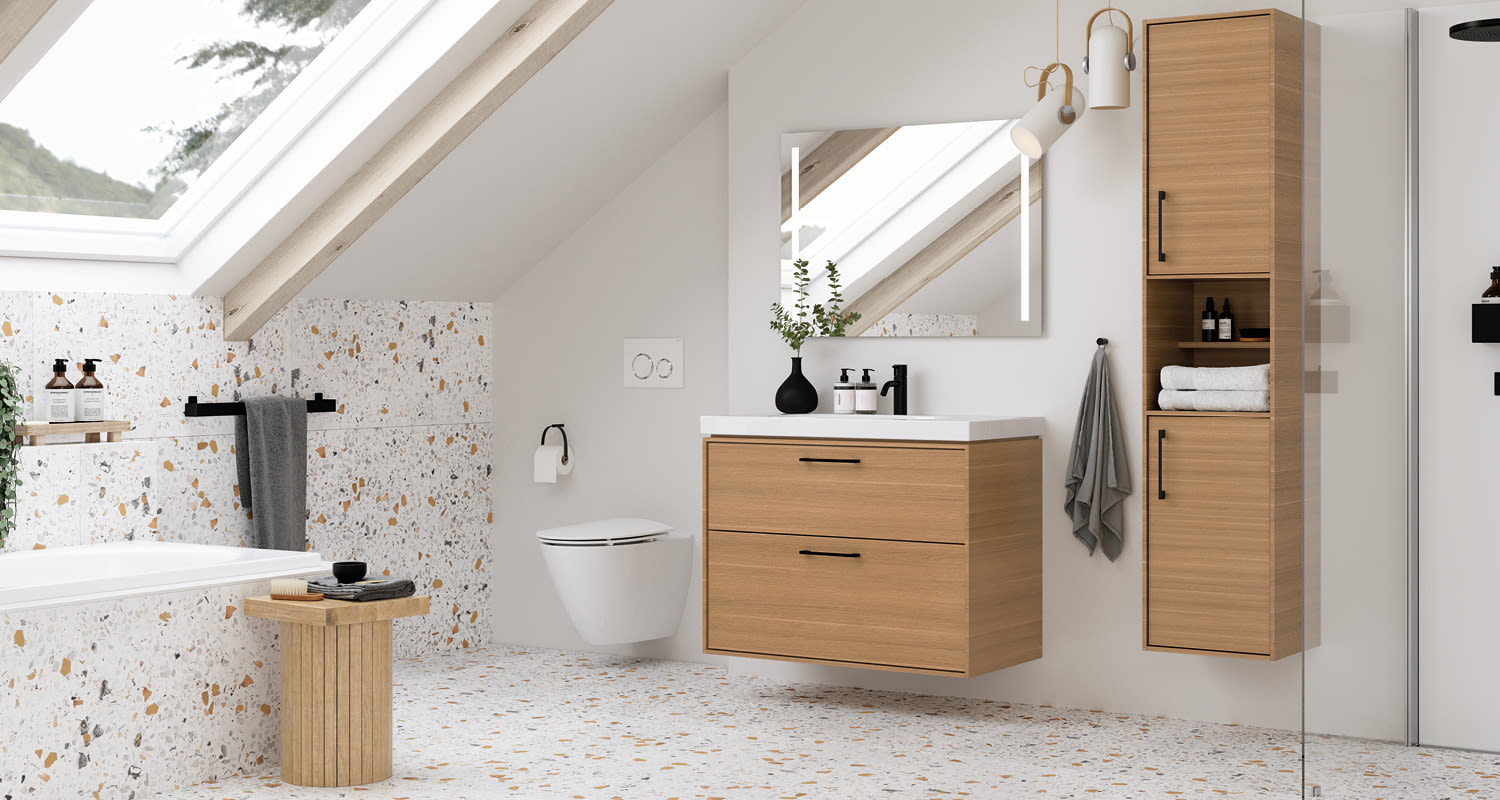 Ullakkokylpyhuone valkoisilla seinillä, terrazzo-lattia, puunväriset kaapit ja kattoikkuna