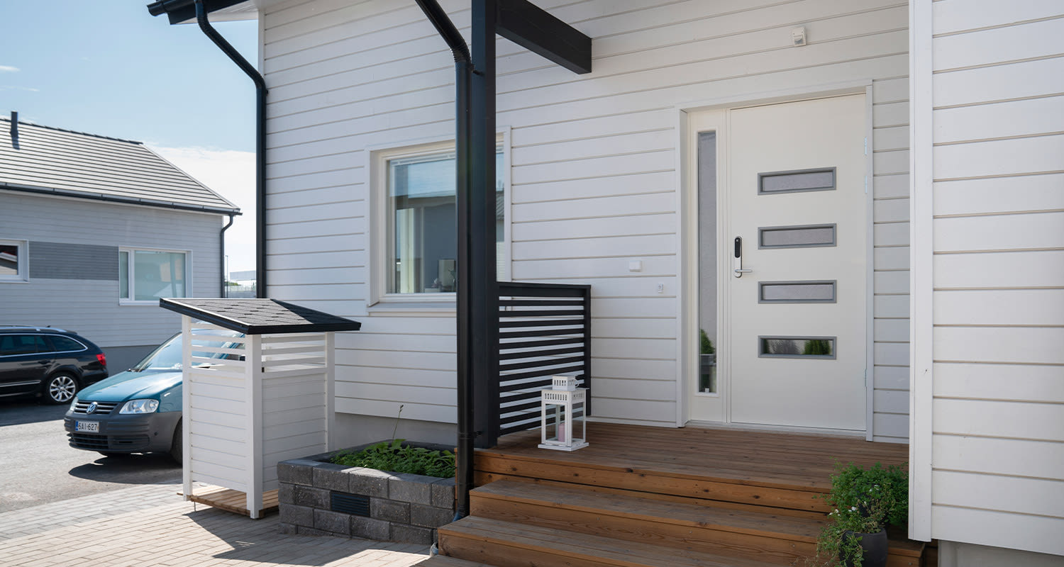 Omakotitalon etupiha ja ulko-ovi.