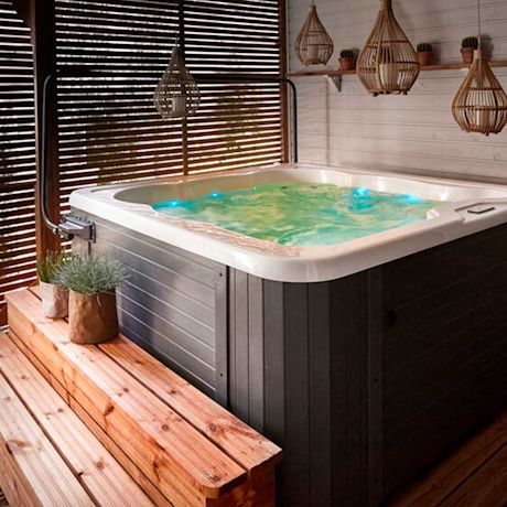 Ulkoporeallas vihreällä valaistuksella puisella terassilla rottinkivarjostimien alla