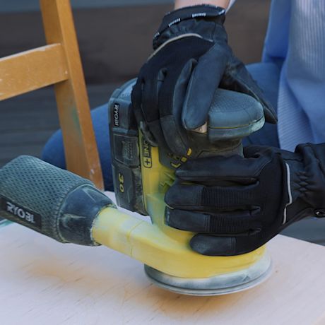 Tuolista hiotaan pois vanha maalipinta epäkeskolla hiomakoneella