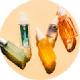 Assorted skincare oils in glass dropper bottles arranged on a circular surface, showcasing different colors and textures.
