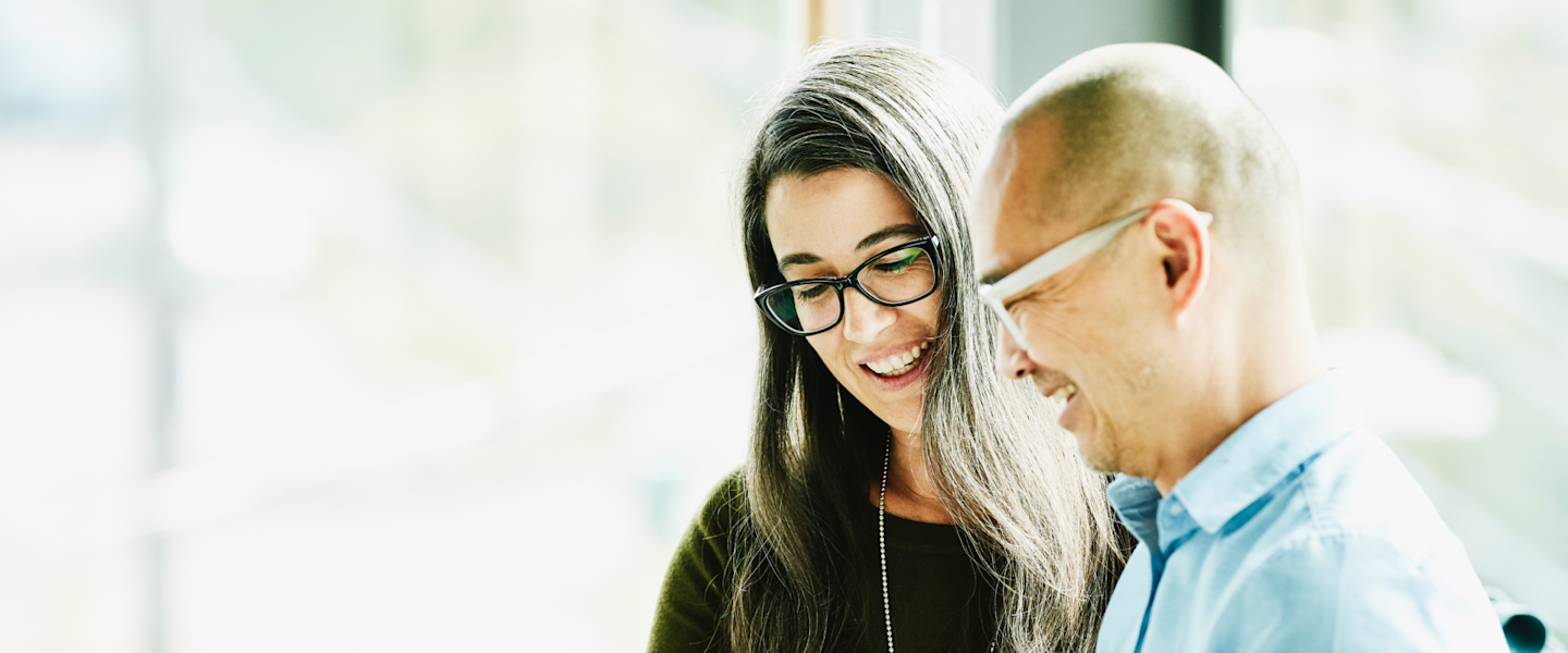 Two people smiling while engaging in conversation.