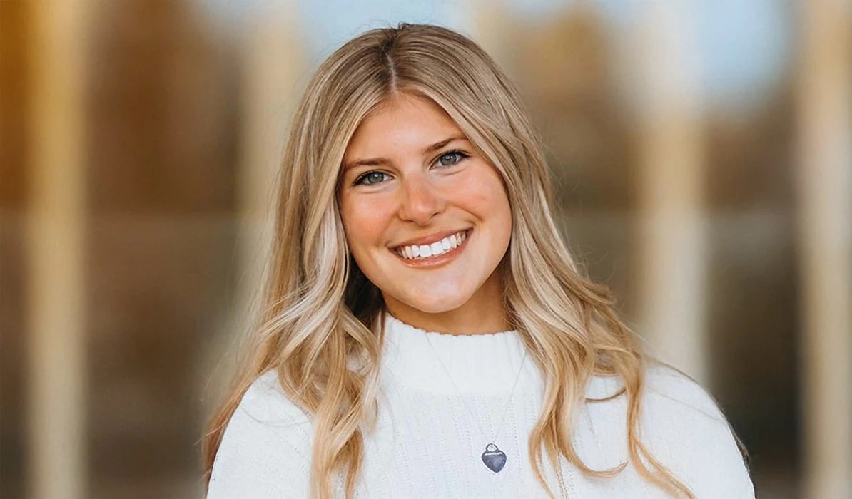 Smiling woman with blonde hair and a white top in a circular headshot.