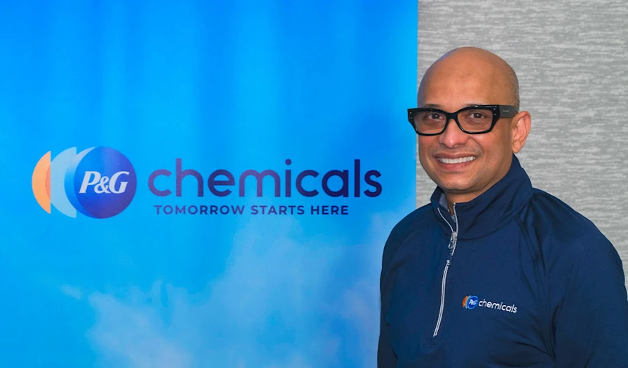 A Man Smiling in front of the "PG Chemicals" logo