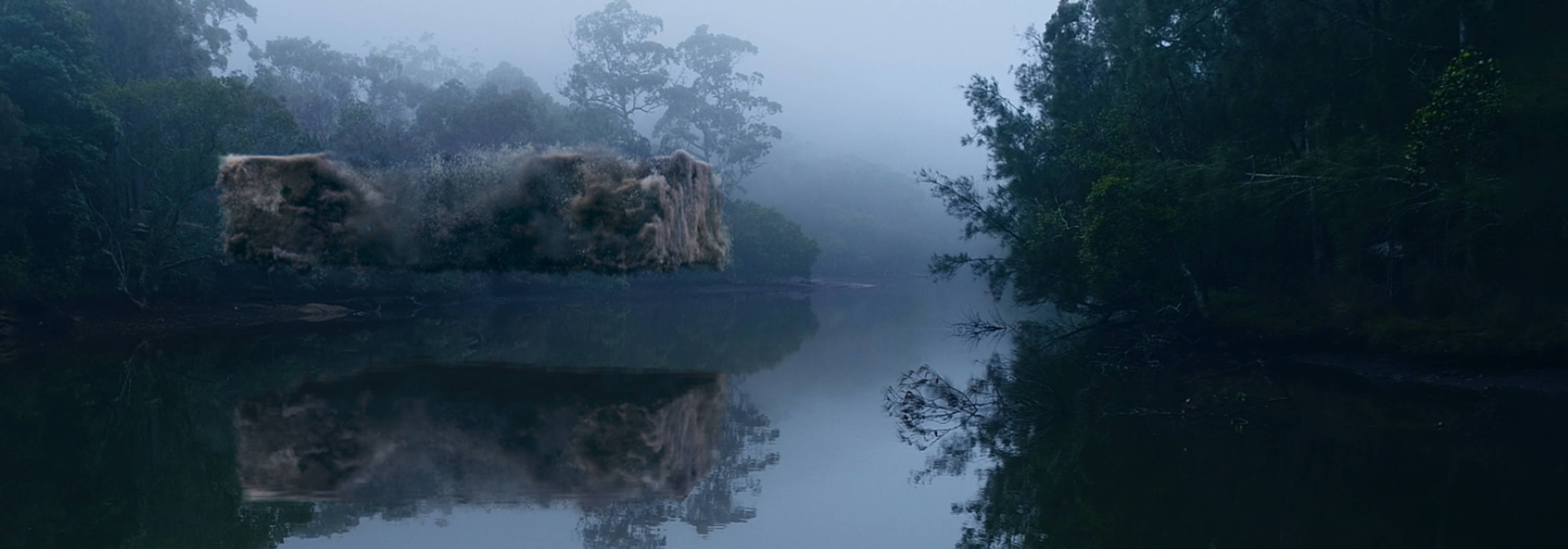 Square-shaped chunk of air pollution floating above a river during a foggy evening.