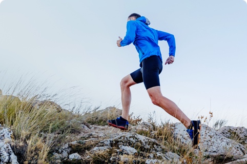 Man running up a rocky hillside.