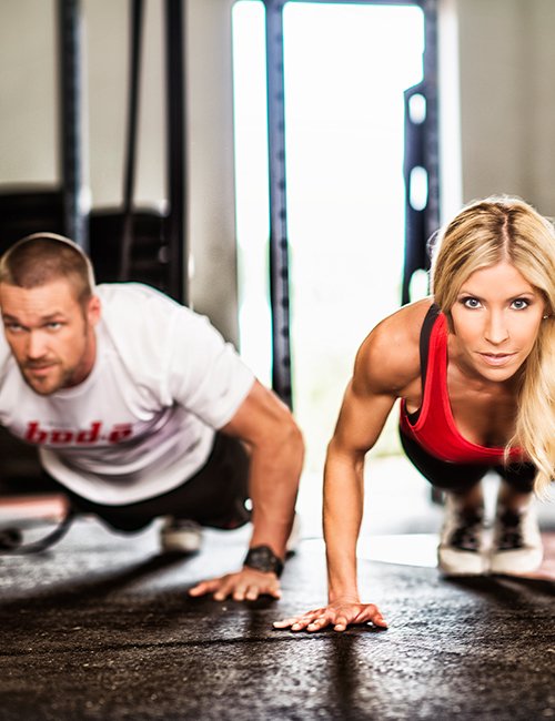 Chris and Heidi Powell doing pushups.