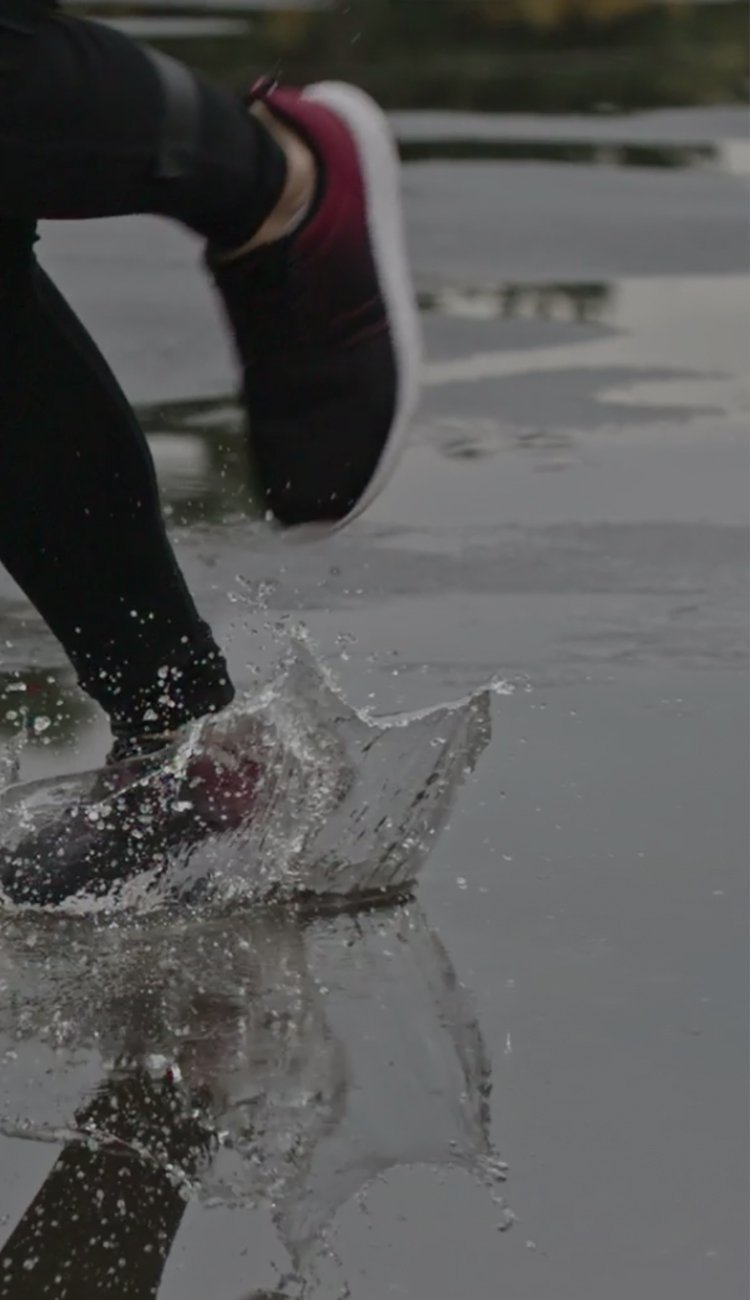 Image of a woman running in puddles.