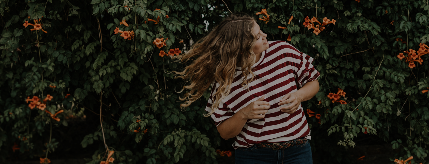 Woman with red and white striped shirt is flipping her hair.