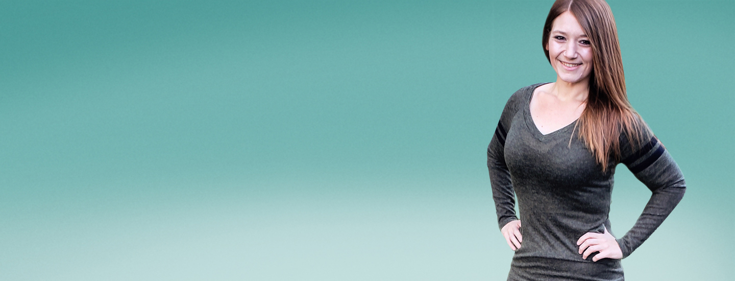Image of smiling Lexi Reed with hands on hips in front of green background