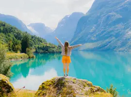 consigli di viaggio settembre: ragazza di spalle che guarda un lago alpino