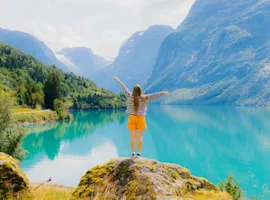 consigli di viaggio settembre: ragazza di spalle che guarda un lago alpino