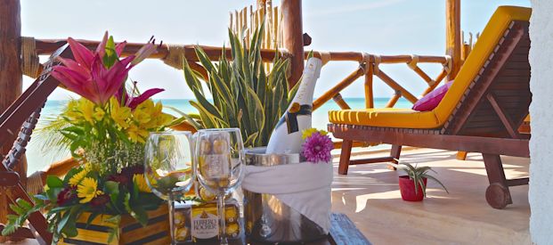 Una terraza con vista del mar y al frente un paquete de bienvenida de champaña