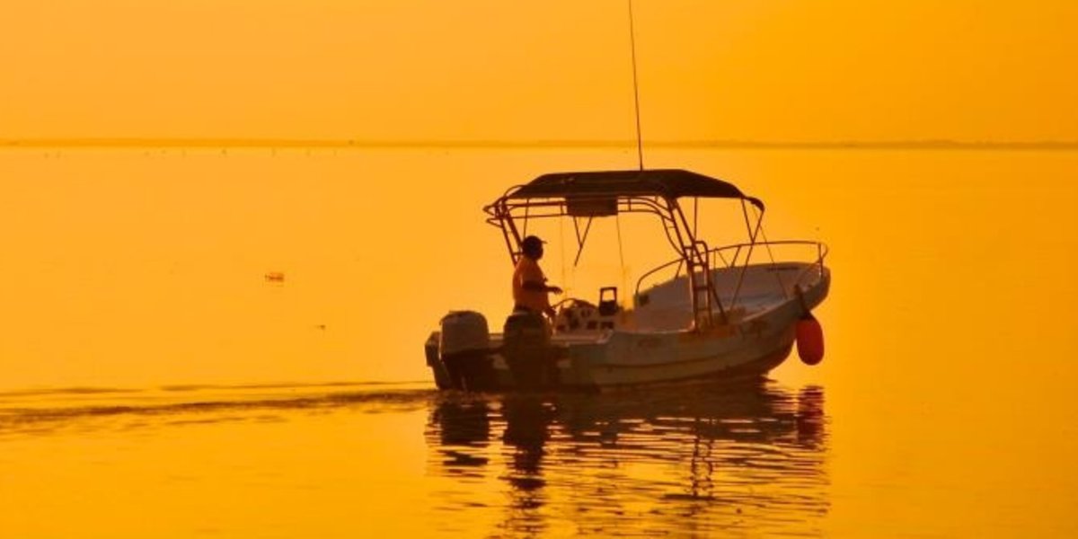 A fisherman in his fishingboat at dawn in Holbox's Laguna Conil