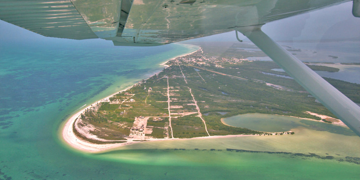 Vista desde una avioneta del lado babor donde se ve el ala y debajo la playa de Punta Cocos en la Isla Holbox. Photo Credit: Šarūnas Burdulis