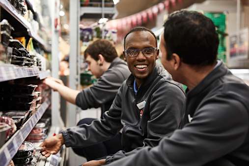 Co-op colleagues smiling while handling meat products