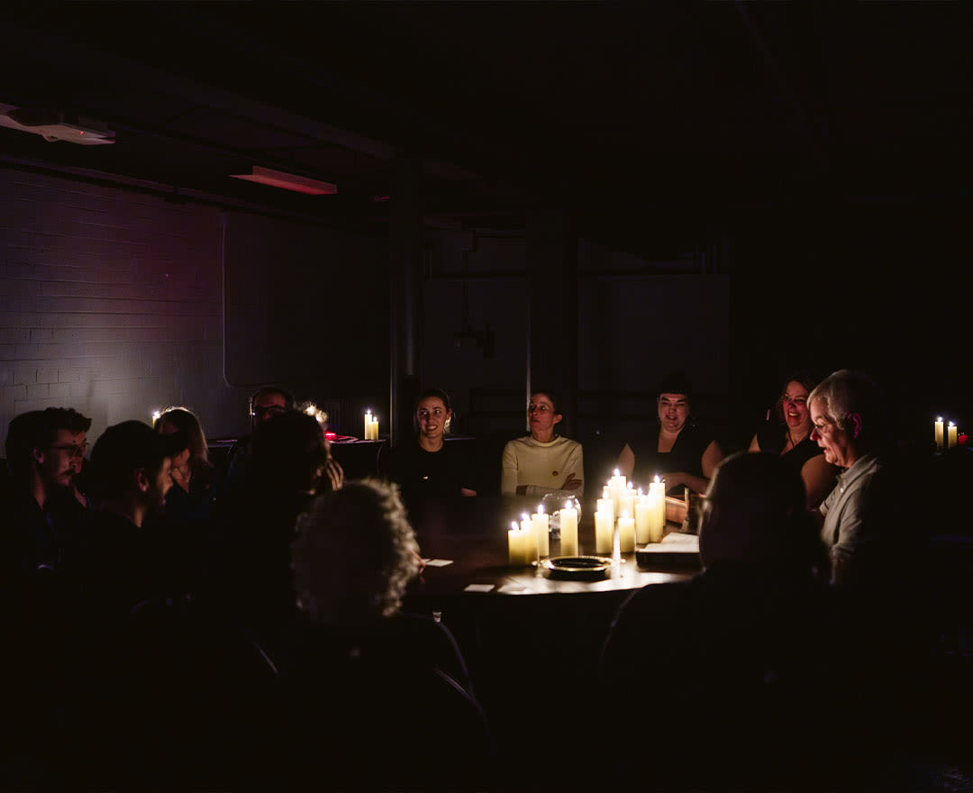 Mentaliste: Une mystérieuse séance spirite en noir et blanc, où plusieurs personnes sont réunies autour d’une table dans une ambiance sombre et intrigante.