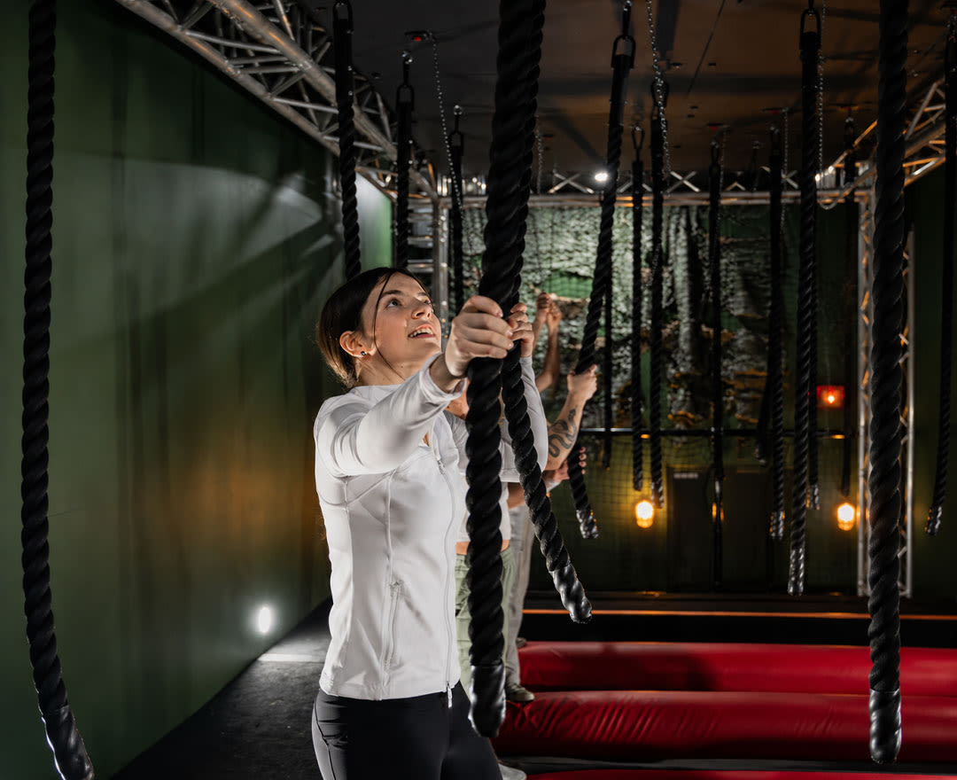 Un montage présente un parcours intérieur de cordes et d’obstacles conçu pour relever différents défis physiques.