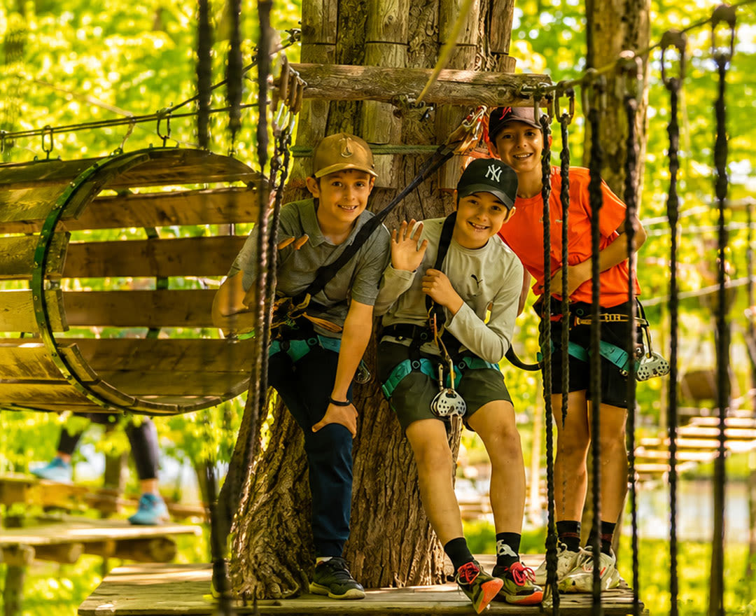 Extéria: Enfants jouant dans un trampoline et une passerelle en bois en pleine nature