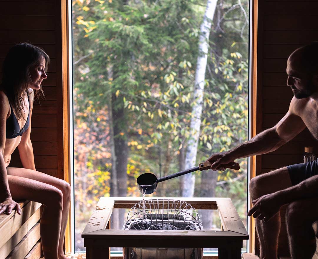 Un couple dans un sauna avec la foret en arriere plan