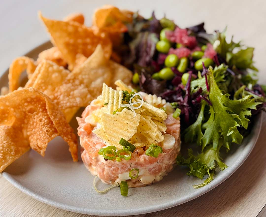 Tartare de saumon servi avec verdure et croustilles de mais
