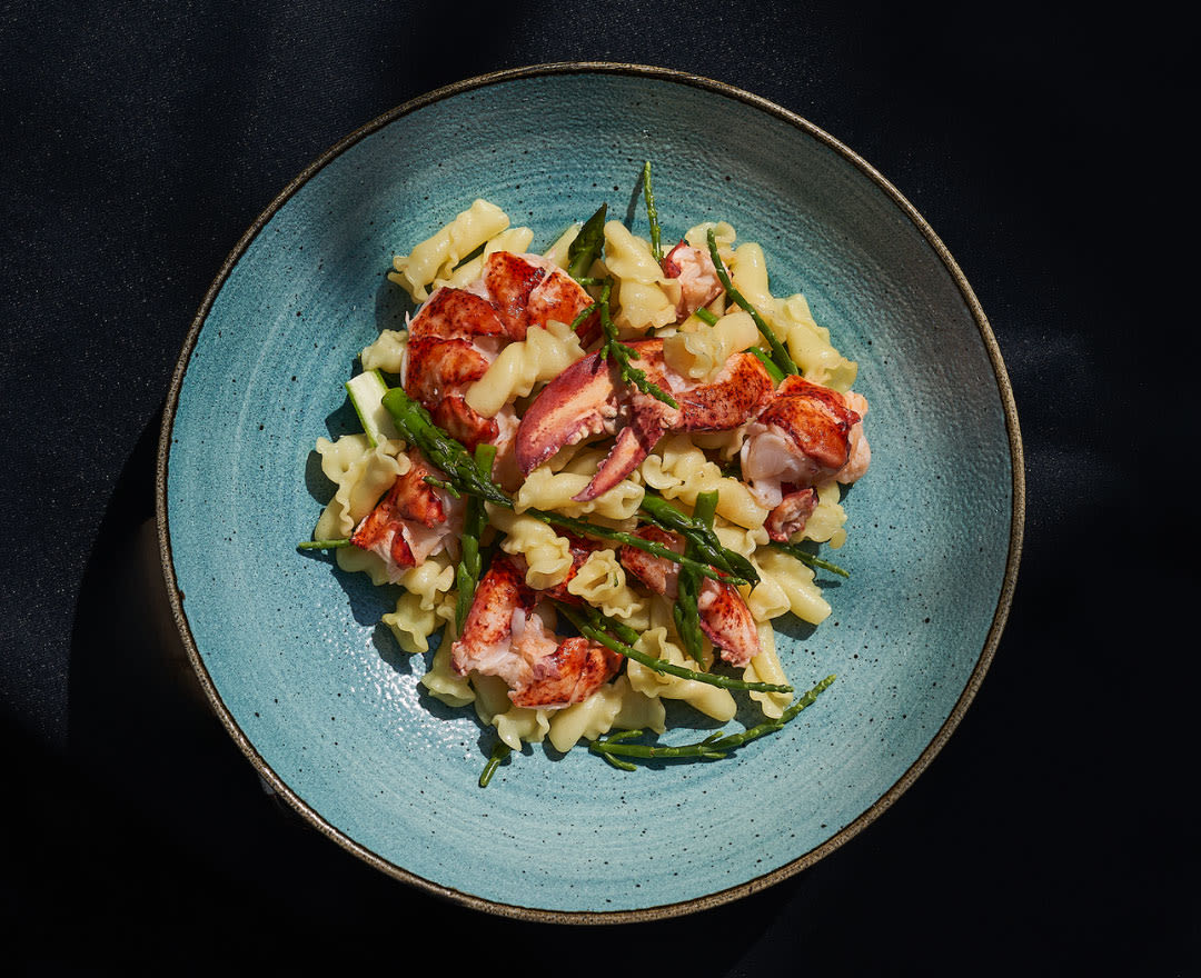 Une pièce de viande grillée et tranchée, accompagnée de brocolis, de verdure et de garnitures raffinées.