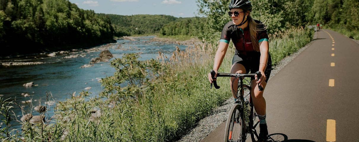 Une fille qui se promène en vélo sur le bord de la rivière
