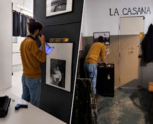 Un homme examine des photos avec une lumière bleue dans une pièce sombre, portant un chandail jaune et un pantalon bleu.