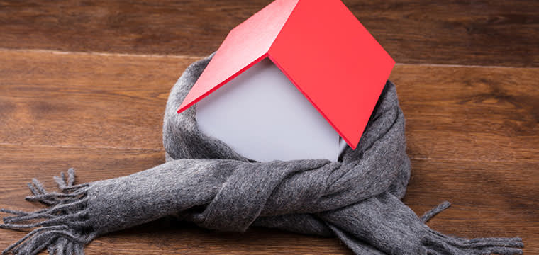 haus-winterfest-machen Haus mit Schal auf Holzboden