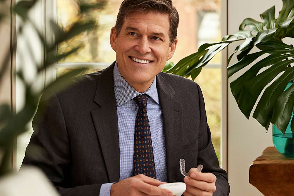 Man in suit with aligners