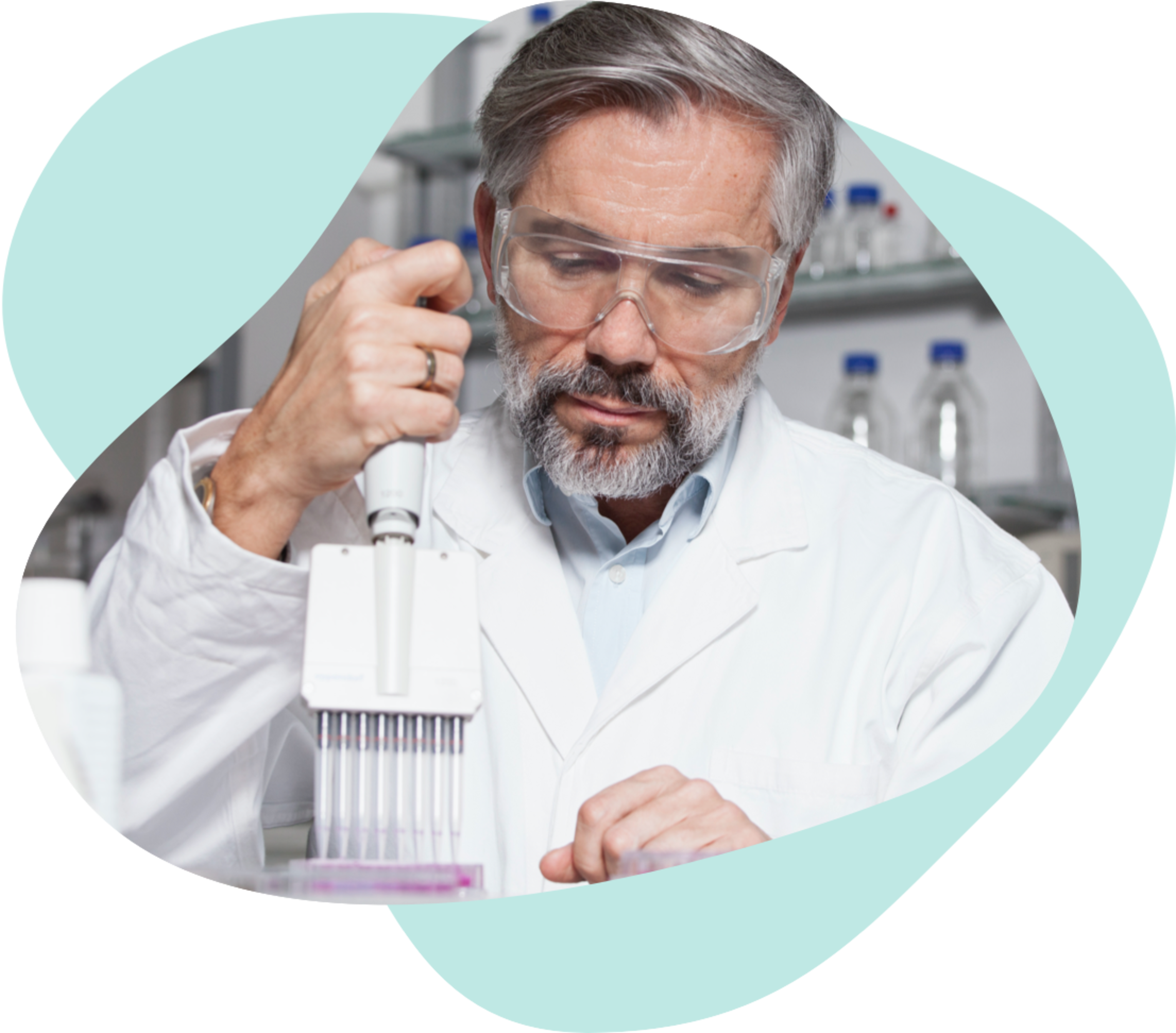 Gray-haired male in white lab coat with protective googles and tubes
