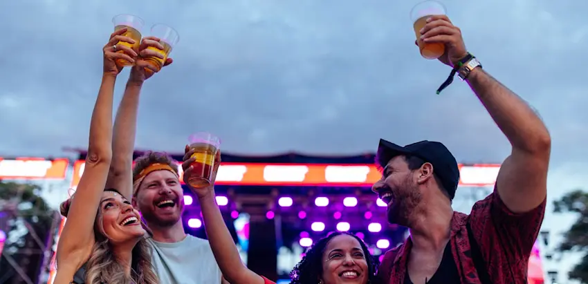 jovens festivaleiros com copos de plástico na mão