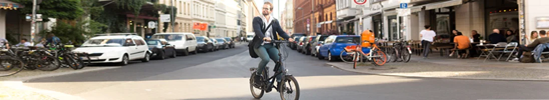 homem no centro da cidade a andar de bicicleta eléctrica