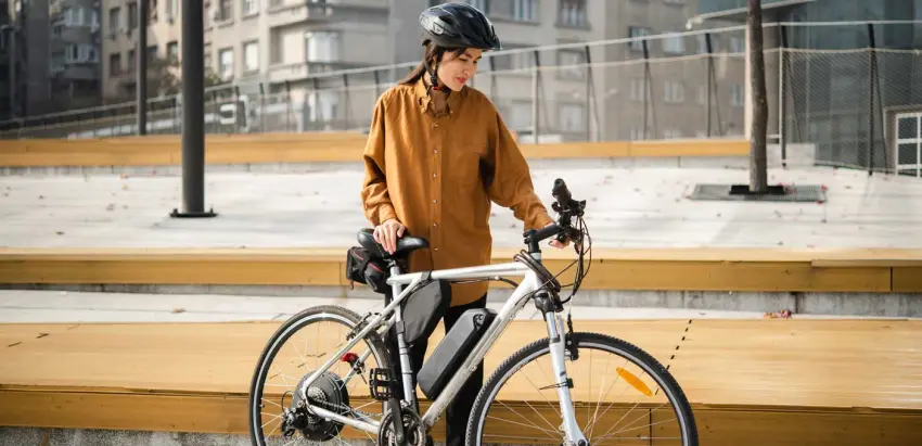 Mulher de capacete e bicicleta elétrica