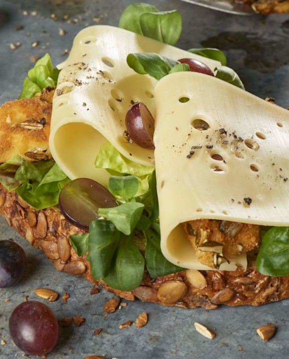 Kürbiskern-Käsebrot mit panierter Hähnchenbrust, Trauben und Feldsalat